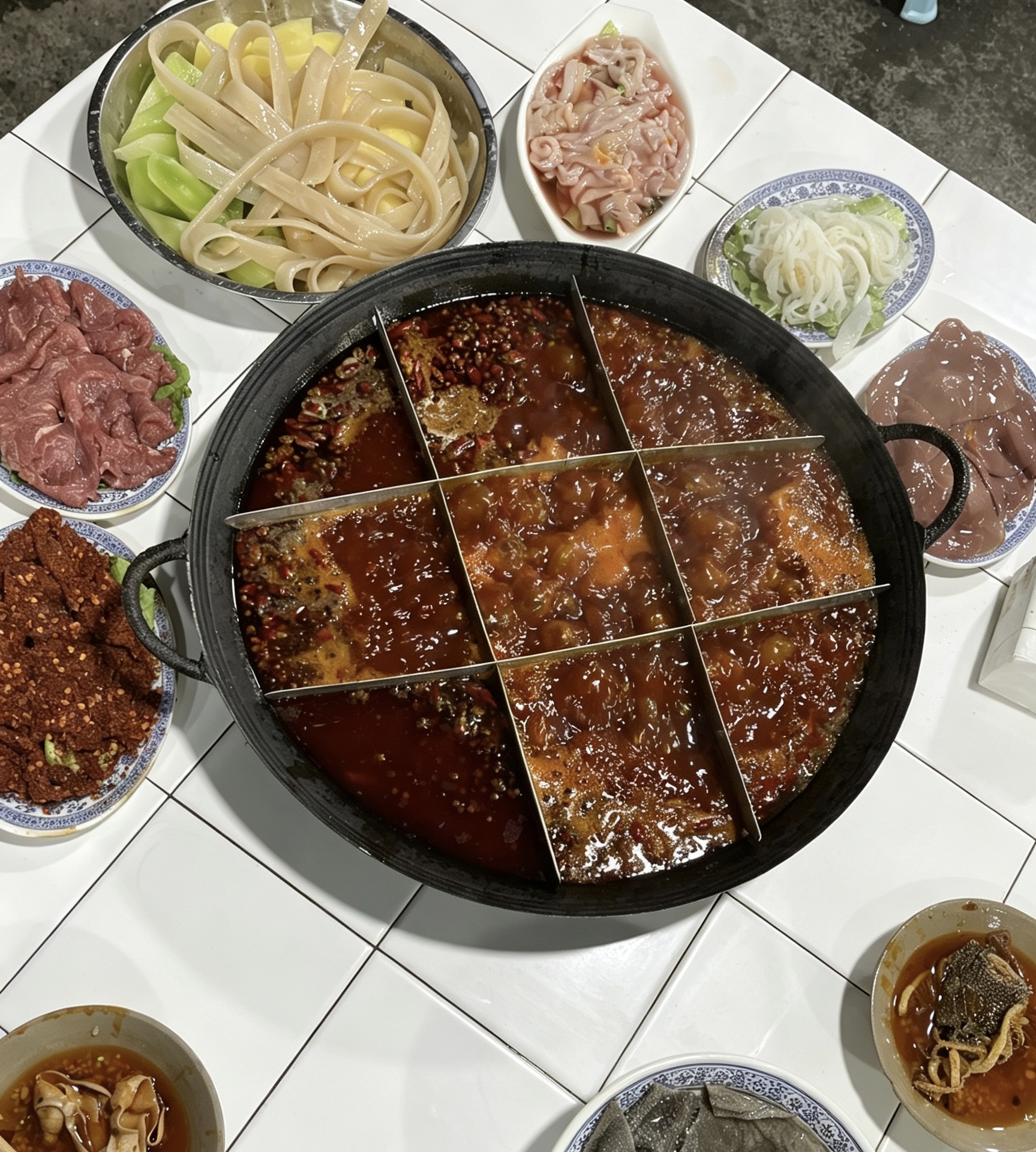 A Chongqing hot pot meal with spicy broth and side dishes